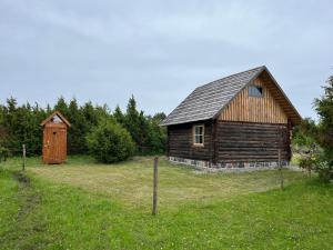 an old barn and a wooden shed in a field at Heinaküün - magamine heinalakas in Pärna