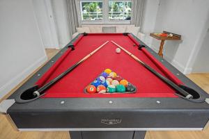 a red pool table with cue balls on it at Splash & Relax Games WiFi BBQ Fire Pit Boat Lake in Royal Palm Beach +63 photos