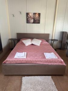 a bedroom with a bed with pink sheets and pillows at IGI Apartments in Bogorodica