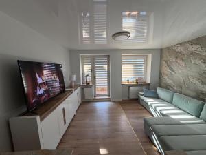 a living room with a couch and a flat screen tv at Anuszka Apartament 3 in Gdynia