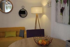 a living room with a table with a bowl of fruit at Apparts Watteau in Limoges +9 photos