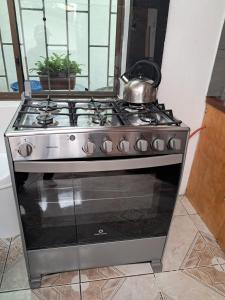 a stove with a tea kettle on top of it at Casa Descanso y Madera in Baños +15 photos