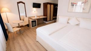 sypialnia z dużym białym łóżkiem i biurkiem w obiekcie Saigon Blue Hotel w Dreźnie