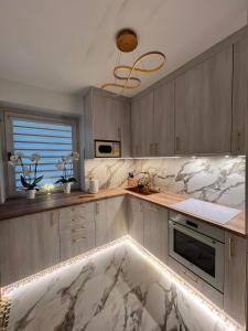 a kitchen with marble counter tops and a sink at Anuszka Apartament 3 in Gdynia