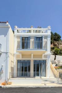 a large white building with a balcony at EARTH VILLA Poros in Poros