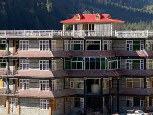 a large building with a red roof at Gems Palace Hotel Naltar in Jugut