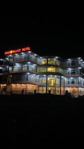 a building with a hotel sign in the night at Gems Palace Hotel Naltar in Jugut +13 photos