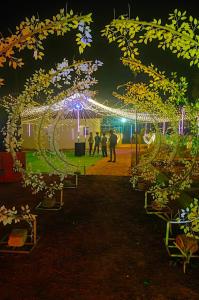 a group of people walking through a garden at night at Ak Green View Beach Resorts in Chīrāla