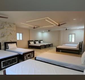 a large room with four beds in it at Ak Green View Beach Resorts in Chīrāla