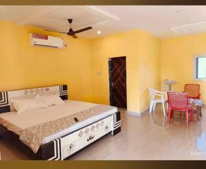 a bedroom with a bed and a table and chairs at Ak Green View Beach Resorts in Chīrāla