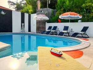 a toy boat sitting on a table next to a swimming pool at Quand la ville dort in Agen