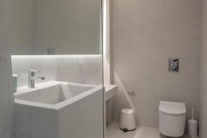 a white bathroom with a sink and a toilet at EARTH VILLA Poros in Poros