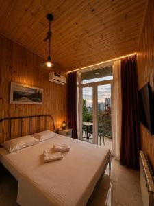 a bedroom with a large bed and a large window at Alis House 3 in Batumi