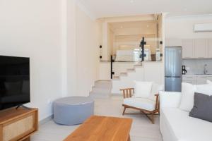a living room with a white couch and a table at EARTH VILLA Poros in Poros