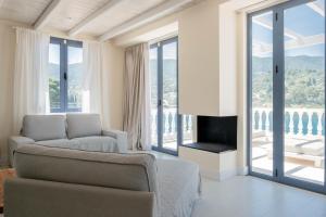 a living room with a couch and a fireplace at EARTH VILLA Poros in Poros +37 photos