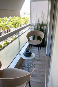 a balcony with two chairs and a vase on a table at CityView Luxury Suite in Alexandroupoli