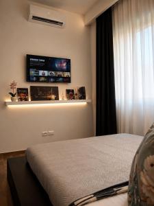 a bedroom with a bed and a tv on the wall at Rebecca's Noir Suite in Reggio Emilia