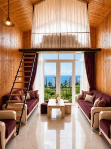 a living room with purple couches and a staircase at Alis House 3 in Batumi