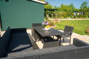 a patio with a table and two chairs and a table and chairs at Aria garden house in Loborika