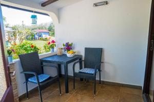 a table and chairs on a patio with a window at Aria garden house in Loborika +13 photos