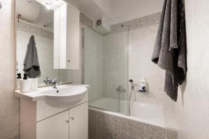 a bathroom with a sink and a tub and a shower at Spartan Gem Apartment in Sparta +7 photos
