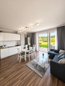 a living room and kitchen with a couch and a table at Morze u Sary - Wrzosowo 361, Dziwnówek in Dziwnówek