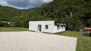 a small white house in front of a mountain at Villa EMELA in Jajce