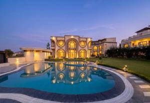 a large house with a swimming pool in front of it at Oryana Resort in Udaipur +11 photos