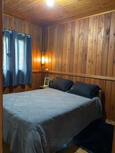 a bedroom with a bed in a wooden wall at Cabana in Annitapolis
