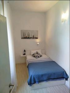 a small bedroom with a bed with a blue blanket at Marko in Fažana