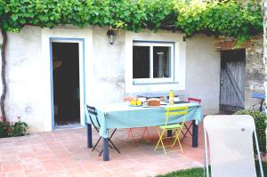 a blue table with chairs on a patio at Chambre dhôtes au pigeonnier in Poulan-Pouzols