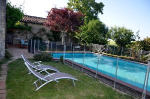 a pair of chairs sitting next to a swimming pool at Chambre dhôtes au pigeonnier in Poulan-Pouzols