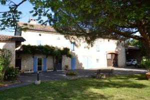 a large white building with a yard in front of it at Chambre dhôtes au pigeonnier in Poulan-Pouzols