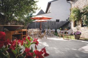 a patio with tables and chairs and an umbrella at Maison Vitis in Fuissé