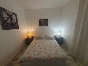 a small bedroom with a bed and two night stands at Le lilas d orly in Orly