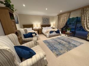 a living room with a bed and a couch and chairs at Marble on 8 in Rustenburg