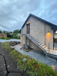a house with a deck and a staircase at Coorie-Tigh in Connel