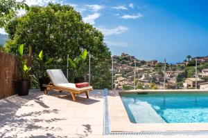 a chair sitting next to a swimming pool at Stunning Deià Views & Private Pool in Deia