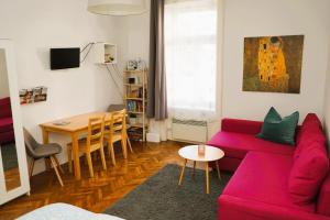 a living room with a red couch and a table at Cozy&Quiet Apartment near Schönbrunnpalace in Vienna