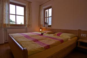 Biohof Niedereben في رابلا: غرفة نوم بسرير وبطانية ونوافذ