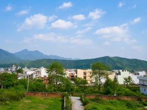 a view of a city with mountains in the background at Thecrestoria in Dehradun