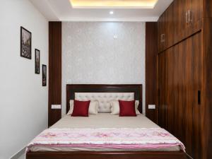 a bedroom with a large bed with red pillows at Thecrestoria in Dehradun
