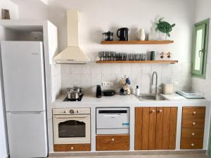 a kitchen with a white refrigerator and a sink at Villa Sofia Traditional Cycladic living in Kampos Paros +4 photos