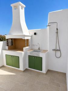 a kitchen with green cabinets and a sink at Villa Sofia Traditional Cycladic living in Kampos Paros