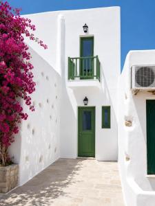 a white building with a green door and flowers at Villa Sofia Traditional Cycladic living in Kampos Paros