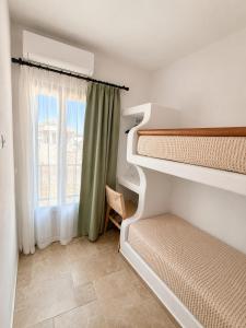 a bedroom with two bunk beds and a window at Villa Sofia Traditional Cycladic living in Kampos Paros