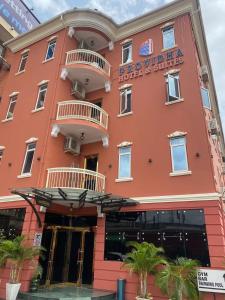 ein rosafarbenes Gebäude mit einem Hotelschild darauf in der Unterkunft Providha Hotel & Suites in Ikeja