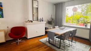 a dining room with a table and a red chair at Light and Spacious Getaway House in Arnhem