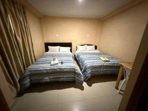 two beds in a small room next to each other at Hostal Tintaya in Cajamarca