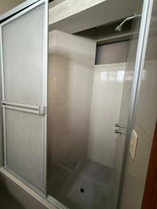 a shower with a glass door in a bathroom at Hostal Tintaya in Cajamarca